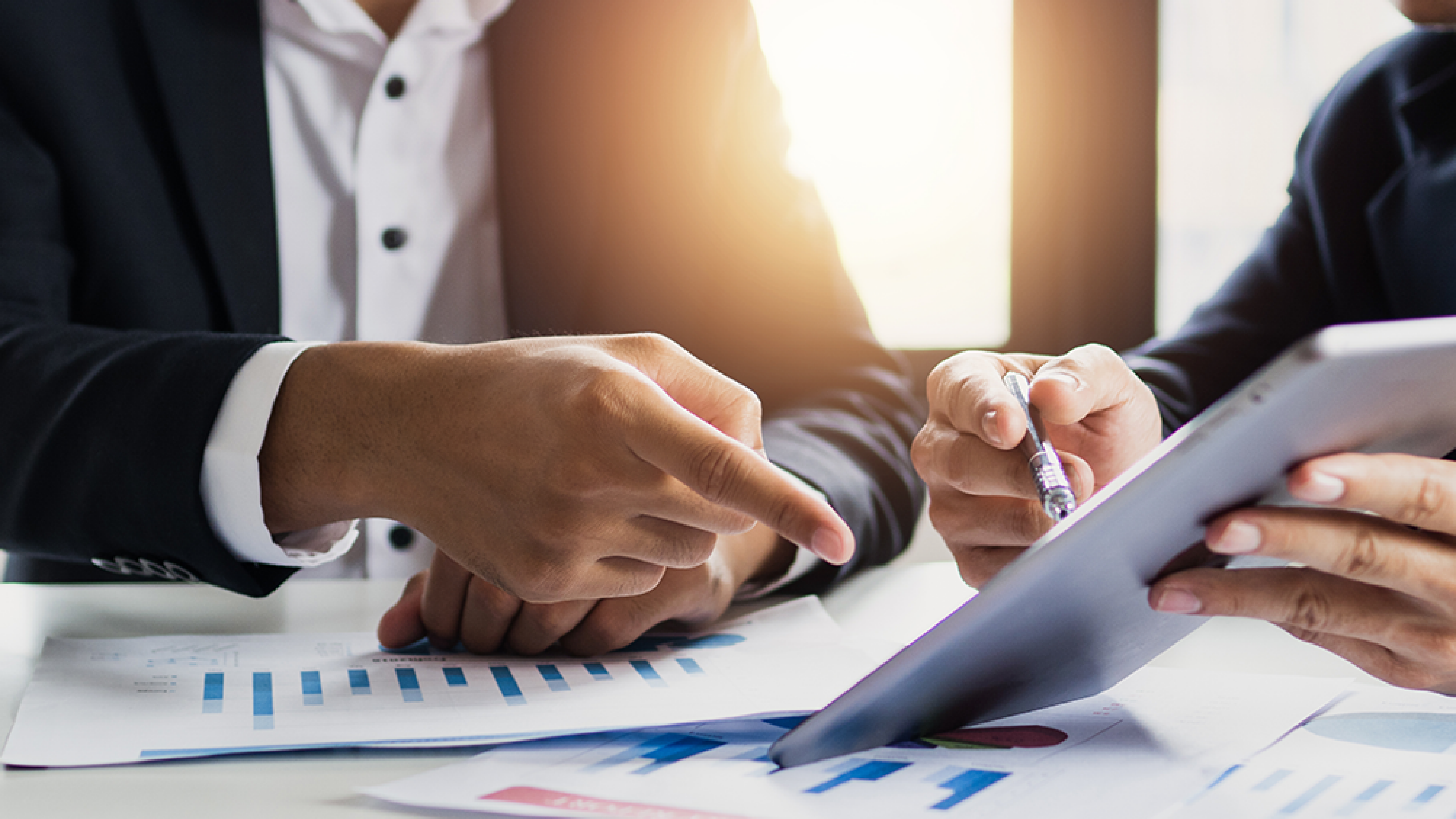 Two business men talking, planning and analyzing investment on a table in an office.